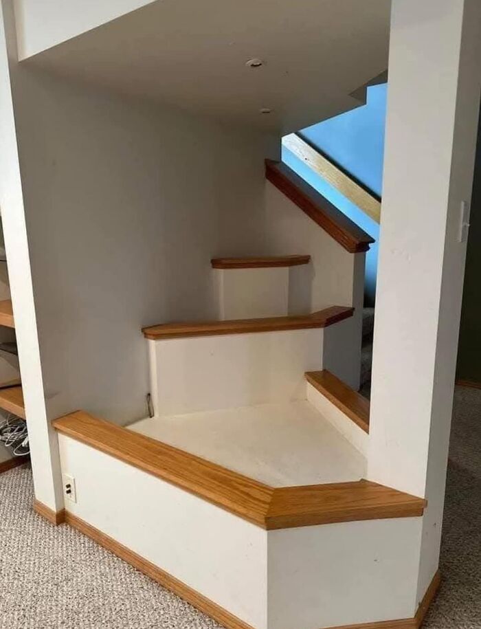Unusable death stairs with irregular and unsafe design in a residential indoor space creating a hazardous step situation.