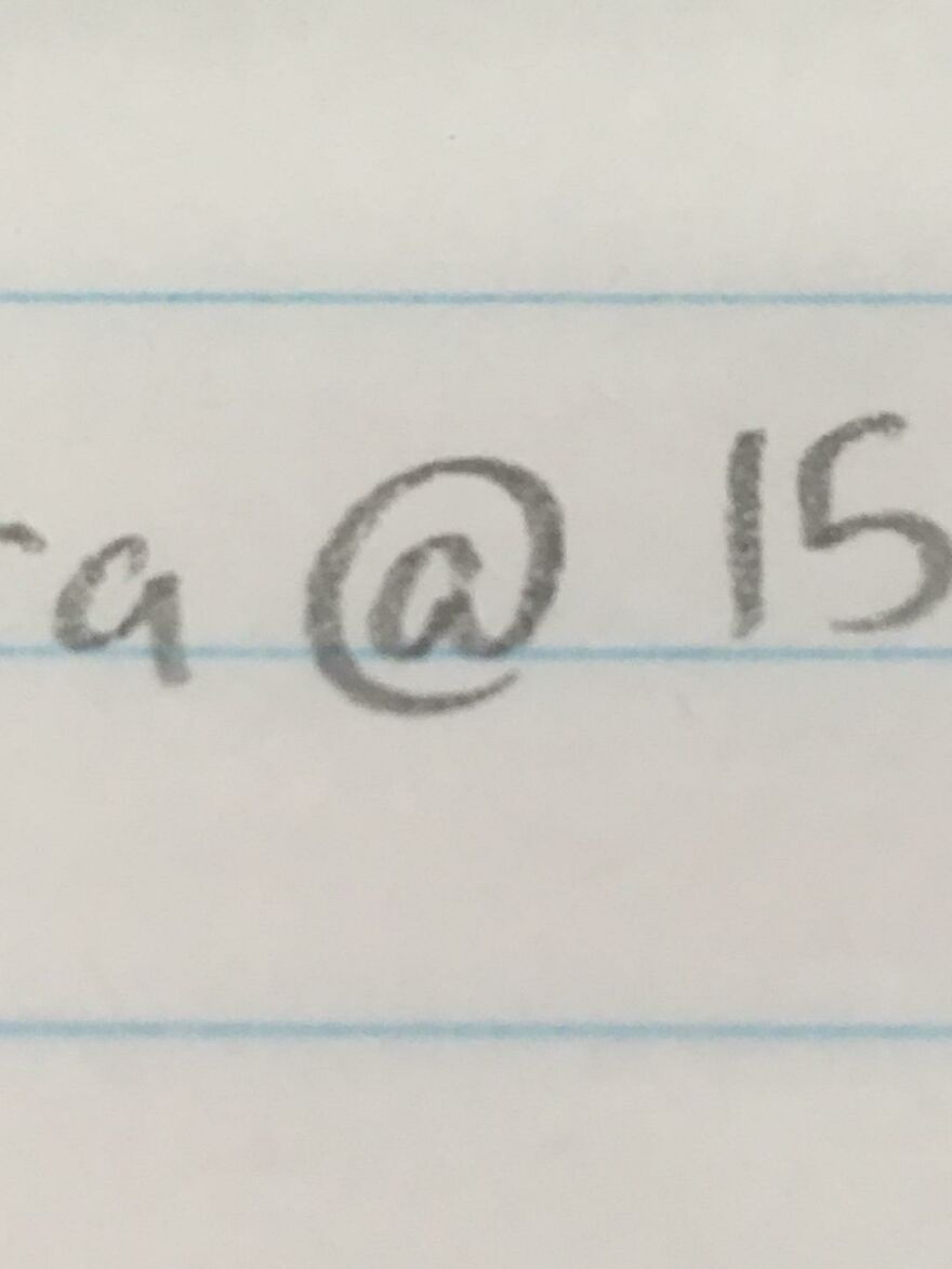Close-up of perfect handwriting example on lined paper showing neat, clear handwritten characters and symbols.