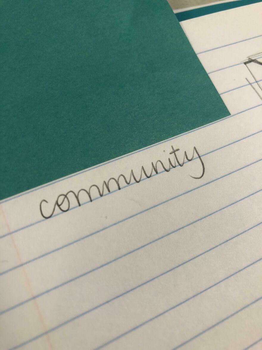 Close-up of perfect handwriting example showing the word community written neatly on lined paper.