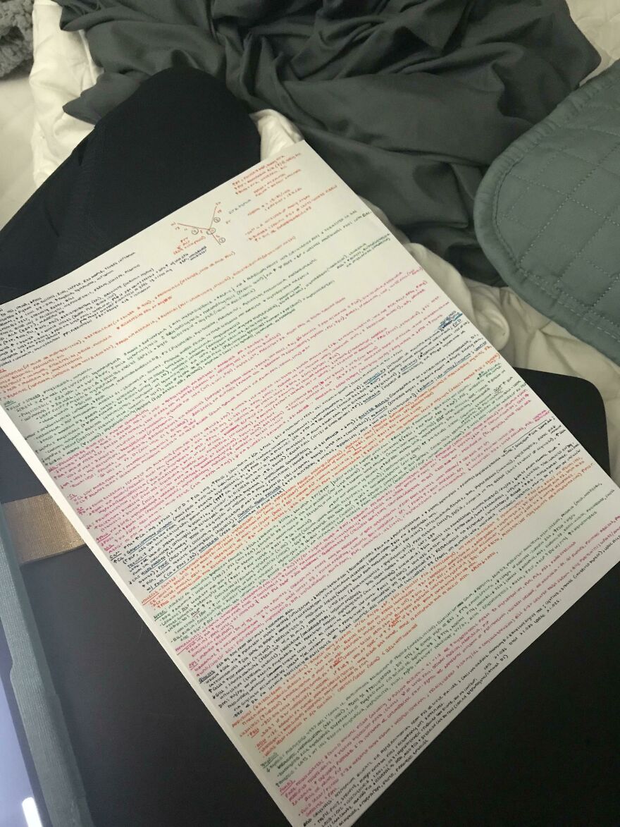 Sheet filled with perfect handwriting examples using multiple colored pens, showcasing neat and precise notes on a bed.