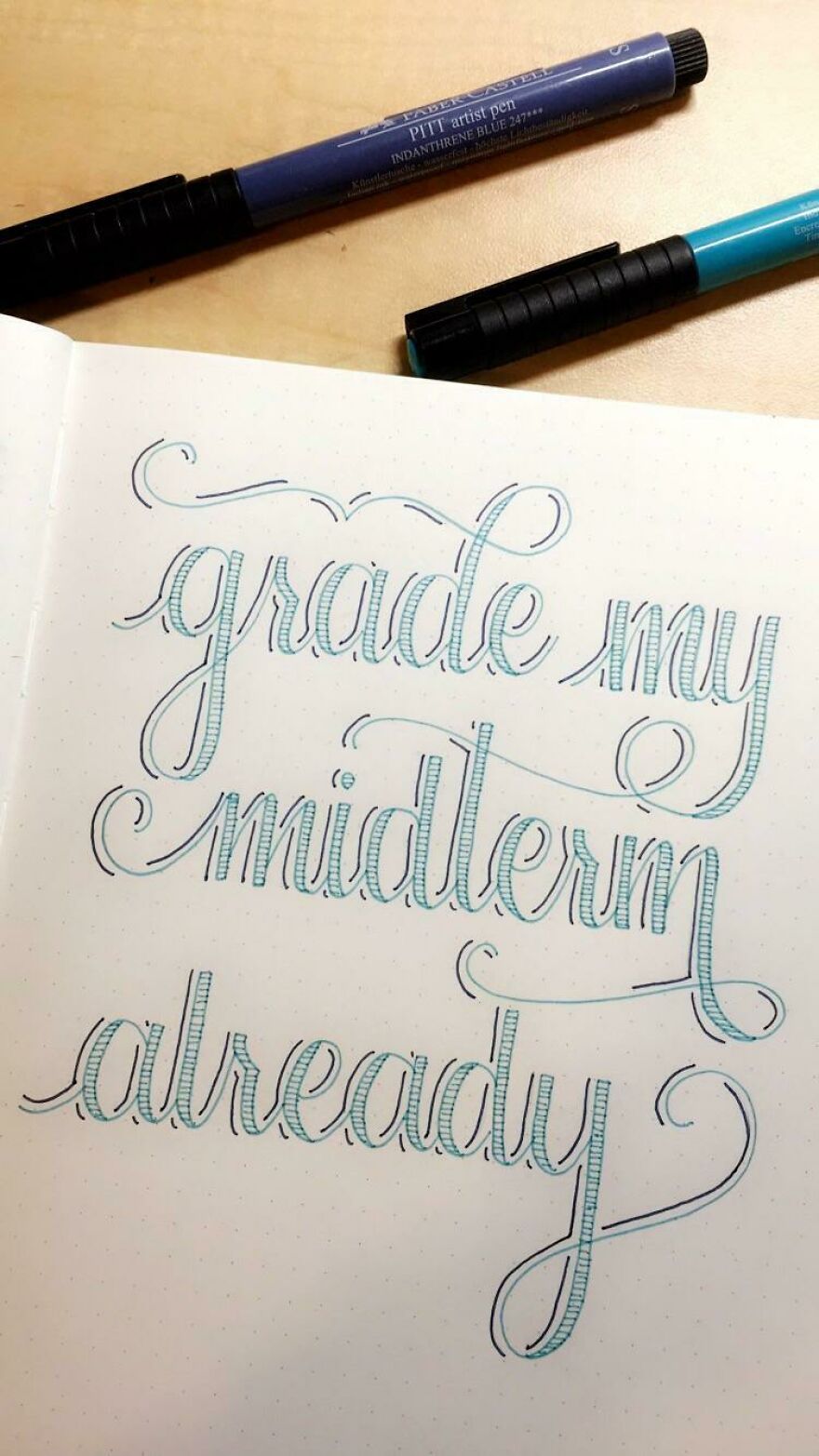 Handwritten calligraphy example with decorative blue and black ink on dotted paper, showcasing perfect handwriting examples.