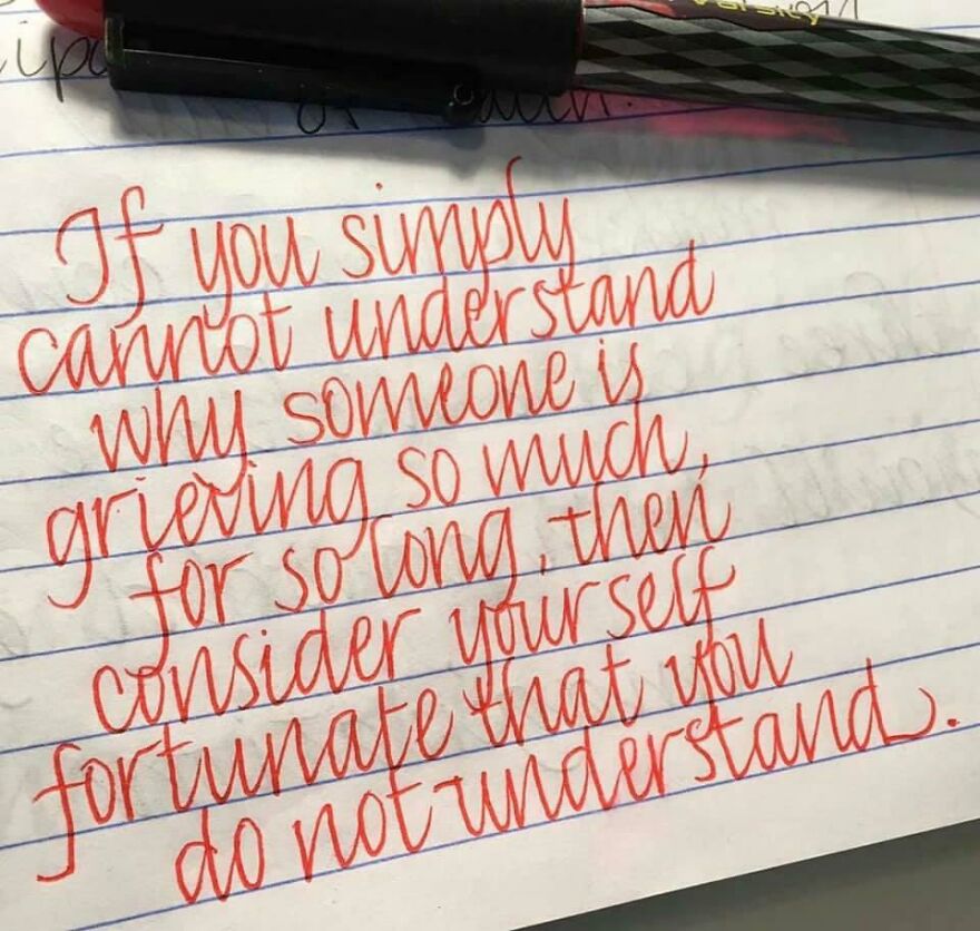 Neatly written motivational quote in red ink showcasing perfect handwriting example on lined paper with a black pen.