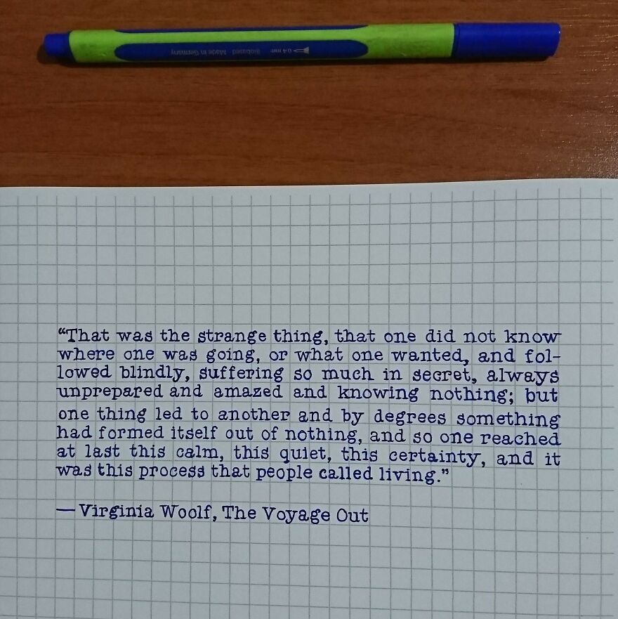 Neat handwritten quote on graph paper using perfect handwriting example alongside a pen on a wooden surface.