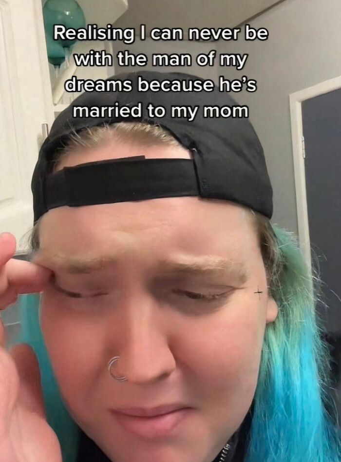 Person with blue hair and a black cap shows exhaustion, illustrating how some relationships can be emotionally exhausting.