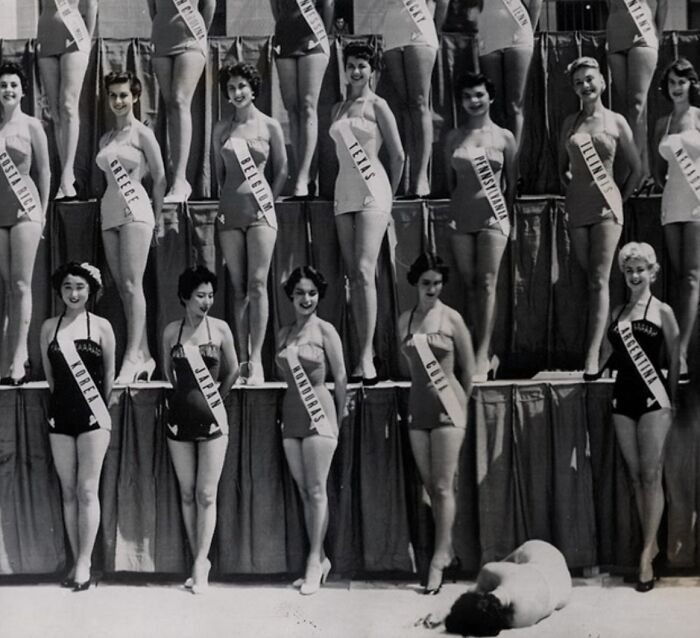Vintage beauty pageant contestants in swimsuits with a person lying on the ground, creating a creepy and unsettling photo.