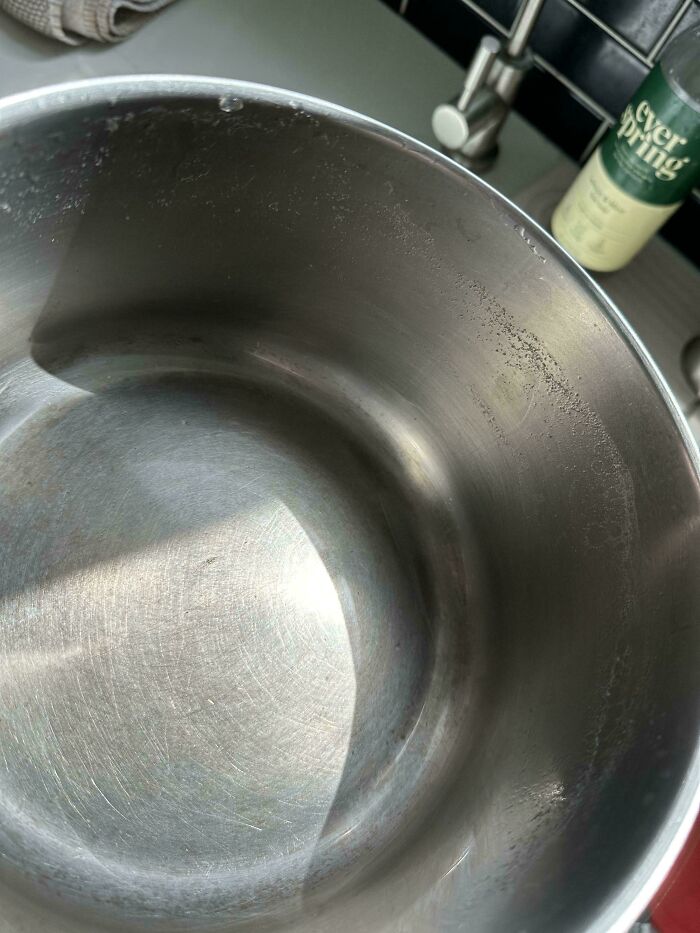 Empty stainless steel pot with water droplets inside, illustrating clueless partner cooking fails in hilarious photos.