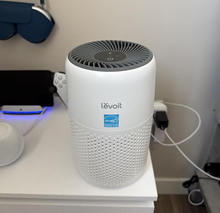 Levoit air purifier on a white table among home electronics, featured in Prime Day home deals for clean air.