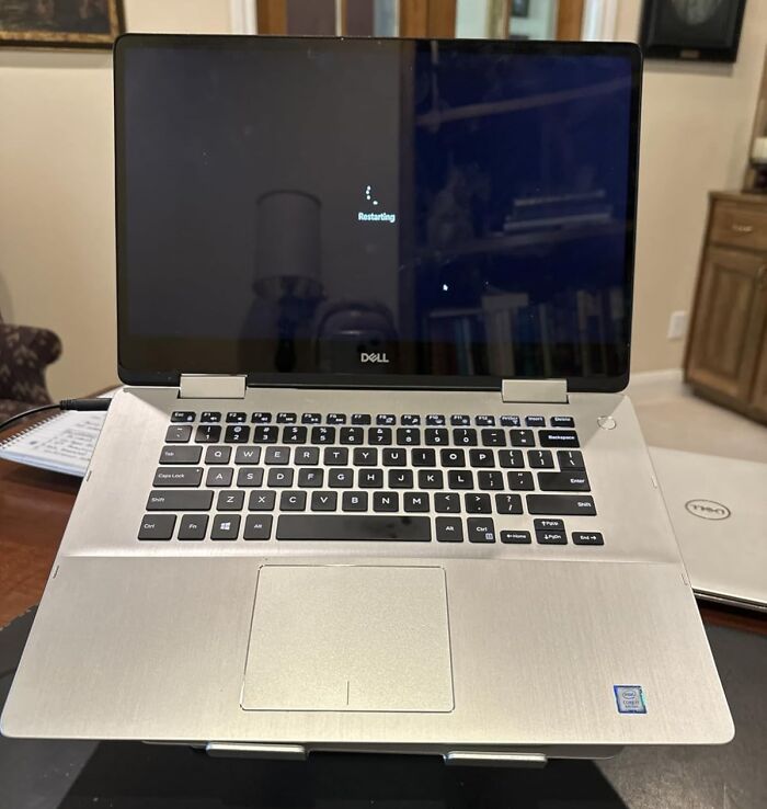 Dell laptop with black keyboard displaying restarting screen, highlighting deals that keep your bank account safe under $25.