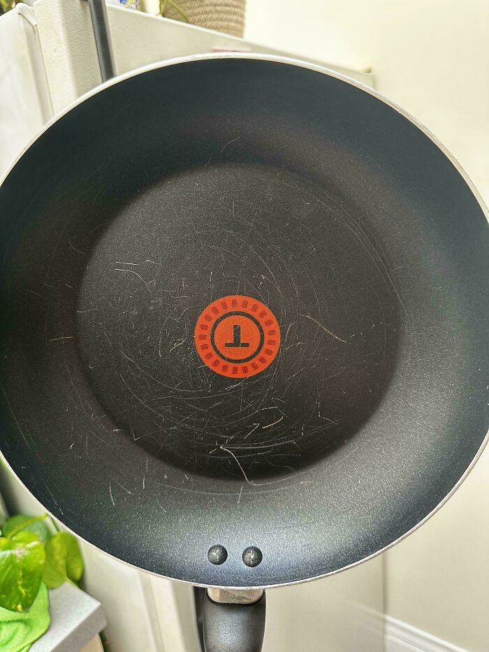 Nonstick pan with visible scratches and wear, illustrating clueless partners' impact on household items.