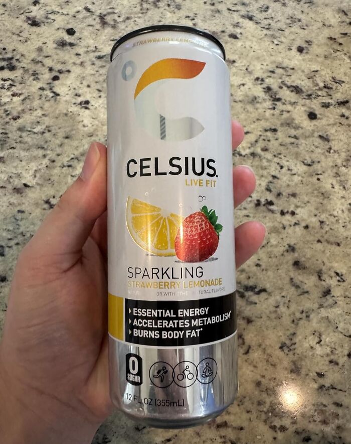 Hand holding a can of Celsius sparkling strawberry lemonade energy drink, featured in Prime Day deals.