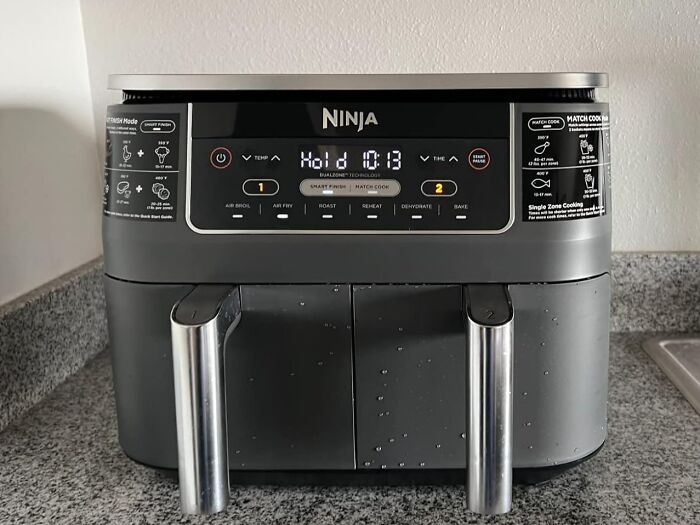 Ninja air fryer on kitchen counter showing digital display with Prime Day deals focus and countdown timer.