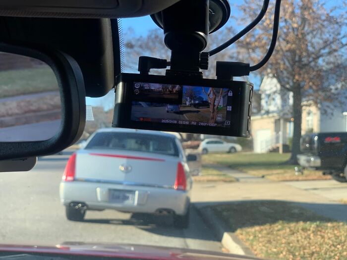 Car dashboard camera mounted on windshield capturing video of parked cars and suburban street scene Prime Day deals.