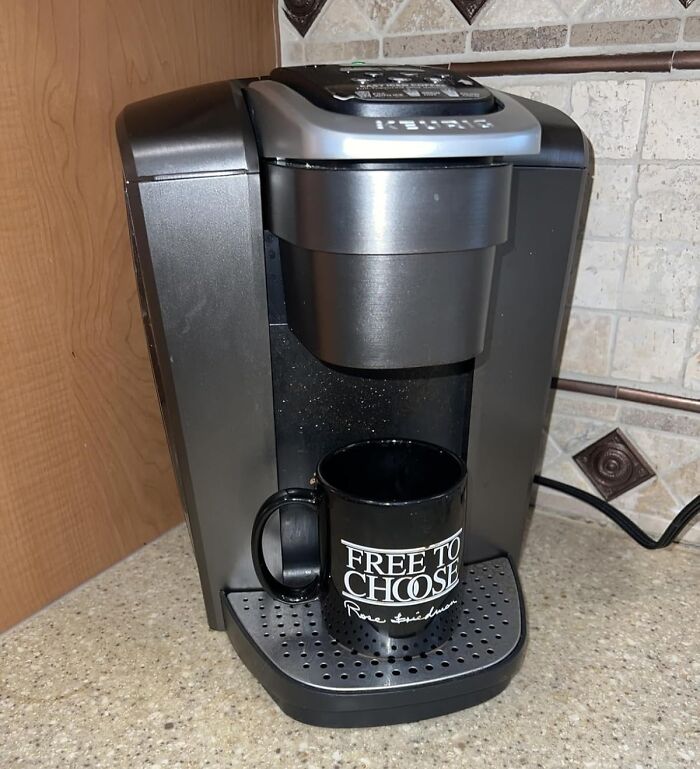 Black Keurig coffee maker on countertop with black mug, highlighting Prime Day deals on kitchen appliances and coffee makers.