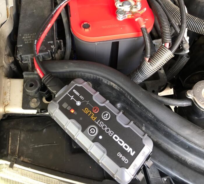 Portable car battery charger connected to a red battery, showcasing popular Prime Day deals on auto accessories.