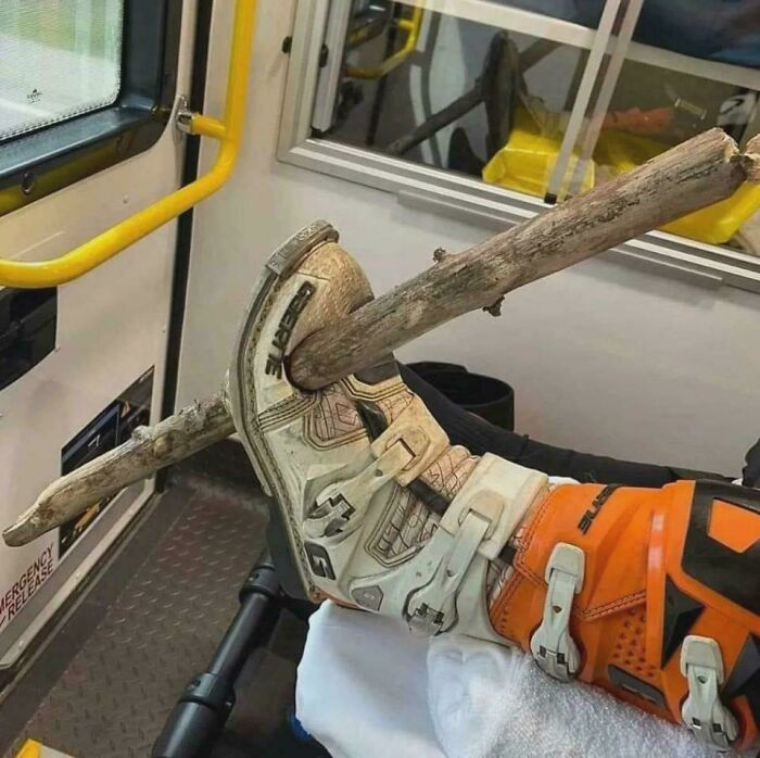 Close-up of a leg with a wooden branch impaled through a motocross boot, showcasing a gory medical case.