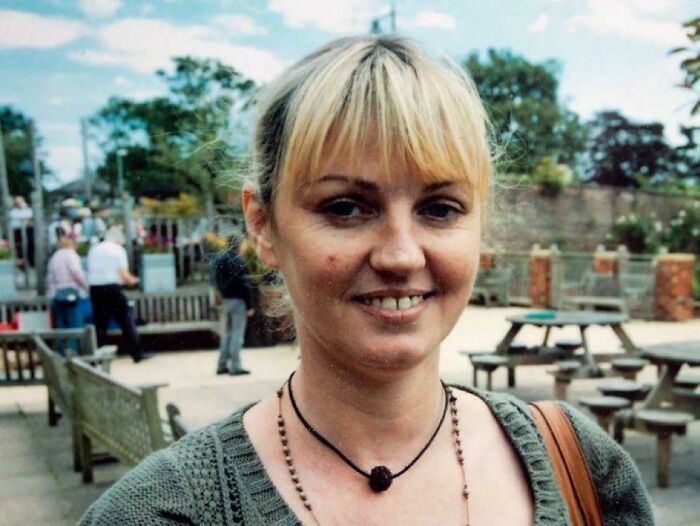 Woman smiling outdoors in a park setting, representing one of the most interesting mysteries that still baffle people.