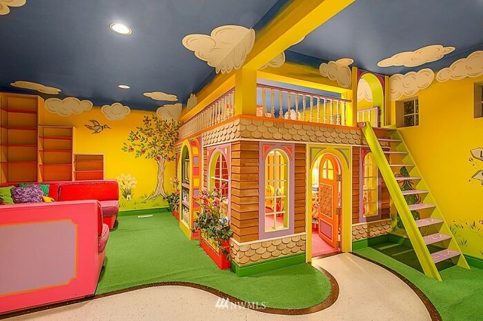 Playroom with a colorful indoor playhouse, bright yellow walls, and whimsical decor in an unusual real estate listing.