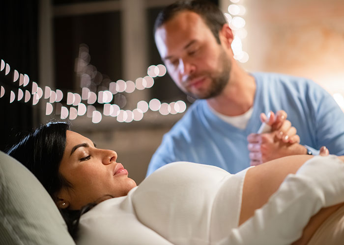 Father holding partner's hand in the birthing room, capturing dads' real experiences during childbirth for the first time.