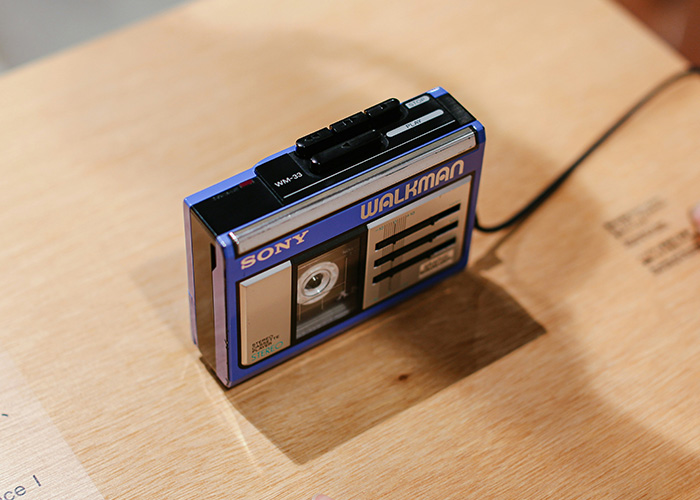 Vintage Sony Walkman cassette player placed on a wooden surface, showcasing obsolete technology still in use daily.