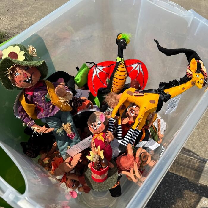 Bin filled with colorful secondhand finds including fabric dolls and plush toys, showcasing unique vintage charm.