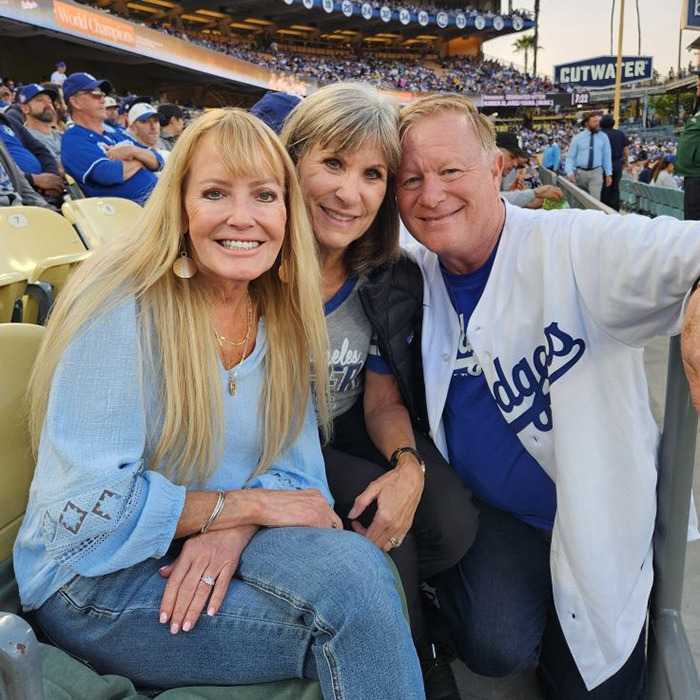 Beloved 70s TV actress with long blonde hair smiling at a baseball game with friends in casual attire Beloved 70s TV actress with long blonde hair smiling at a baseball game with friends in casual attire
