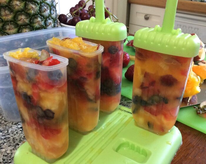 Colorful fruit popsicles in a green mold, perfect for a beach day to conquer sun, sand, and snack attacks.