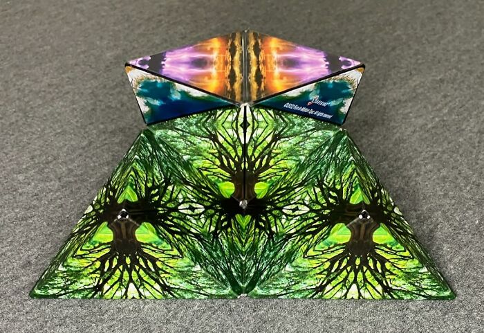 Abstract pyramid art piece featuring mirrored tree designs and vibrant colors, inspiring your creative spirit and arty finds.