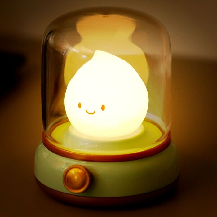 Glowing cute light with a smiling face inside a retro-style glass dome, a seriously sweet discovery adding aww factor.