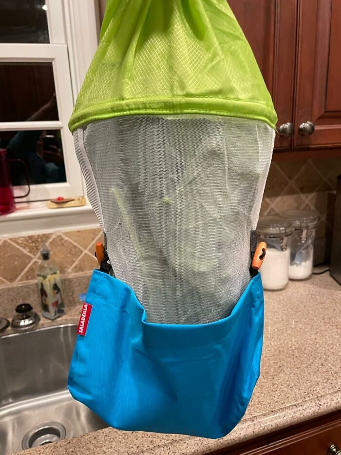 Mesh bag with clothespins and a blue pouch hanging in kitchen, showcasing designers solving hyper specific life issues.