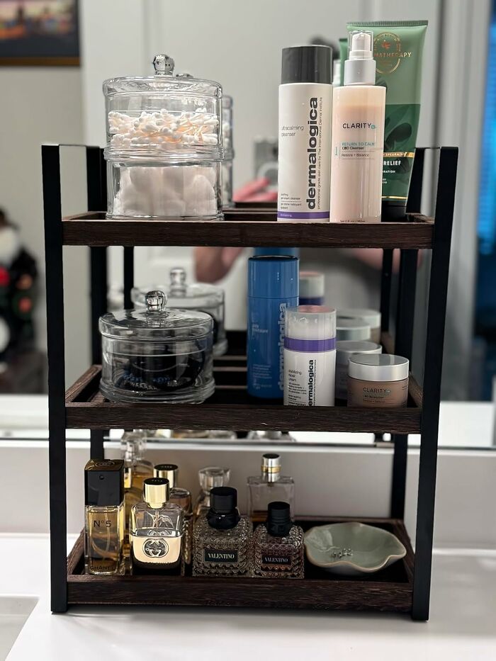 Wooden shelf with skincare products, glass jars, and perfume bottles showcasing Prime Day home deals organization.