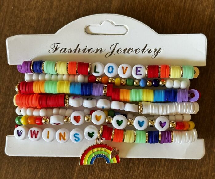 Colorful pride bracelets with rainbow beads and charms, featuring positive messages and vibrant fashion jewelry pieces.