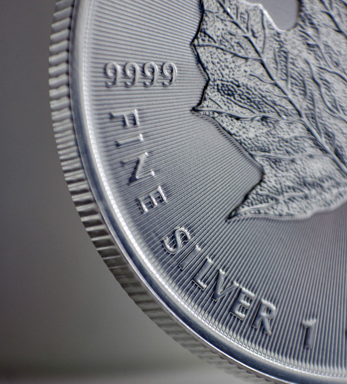 Close-up of a silver coin edge with fine details, highlighting texture and inscriptions related to old wives' tales.