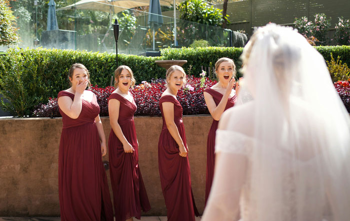 Bridesmaids in matching dresses reacting with surprise as bride in veil approaches, highlighting maid of honor pregnancy weight issue. Bridesmaids in matching dresses reacting with surprise as bride in veil approaches, highlighting maid of honor pregnancy weight issue.