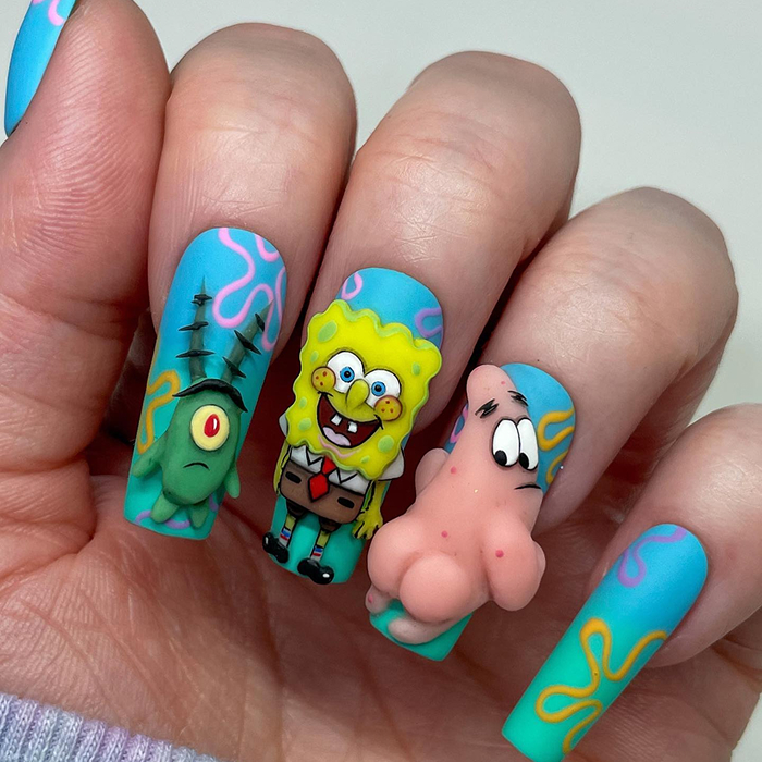 Close-up of colorful summer nails with floral and fruit designs showcasing 2025 hottest summer nails trends.