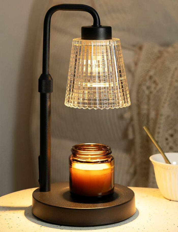 Black metal lamp with textured glass shade illuminating a candle jar, showcased as a Prime Day home deal.