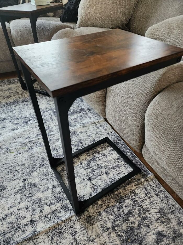 Modern wooden side table with metal frame beside beige couch on patterned rug, showcasing Prime Day home deals.