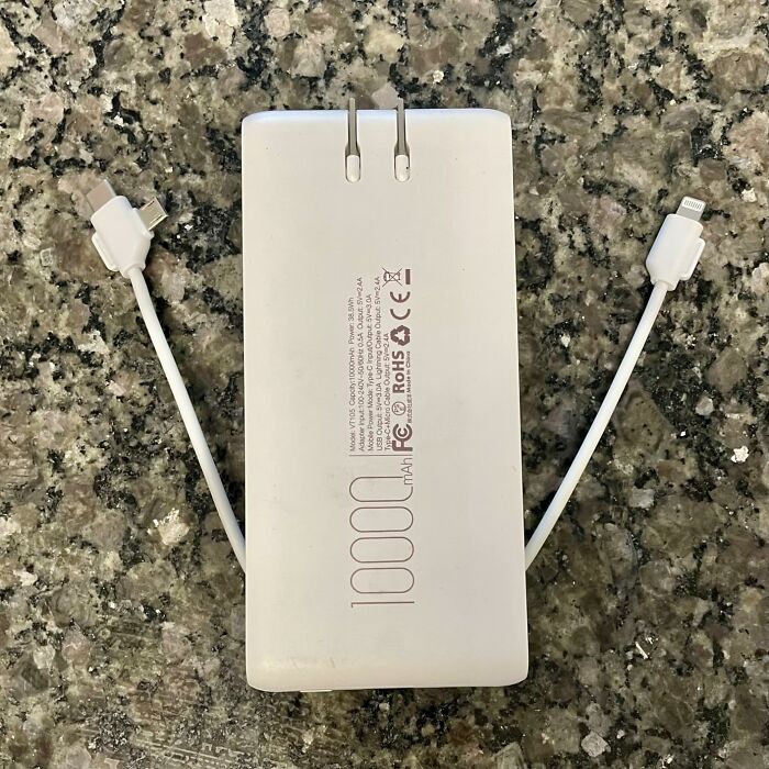 Portable power bank with two charging cables on granite surface representing budget-friendly Prime Day deals under $25