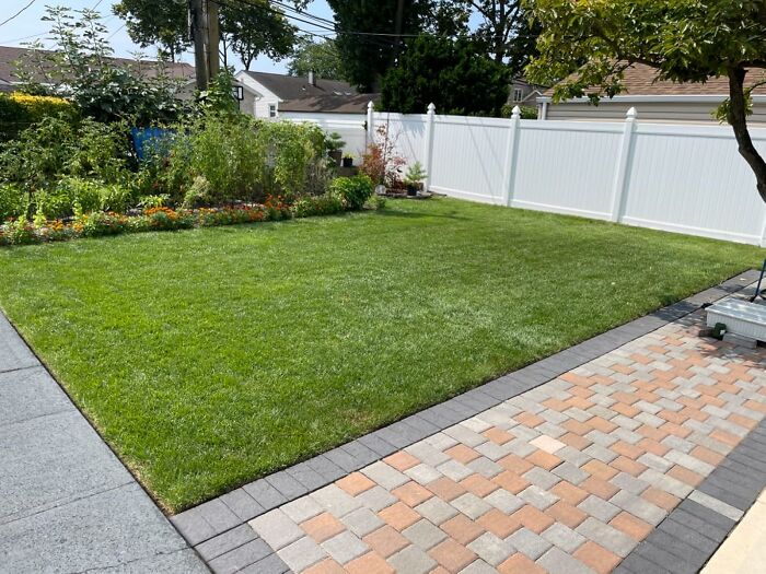 Well-maintained backyard with green grass and garden, illustrating genius ways to fix all your little glitches during Prime Days.