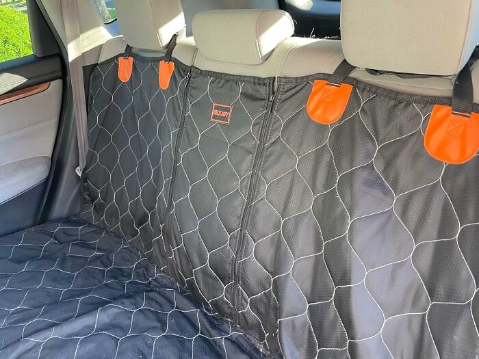 Car seat protector with orange clips installed on back seats, a clever car find to trick out your commute.