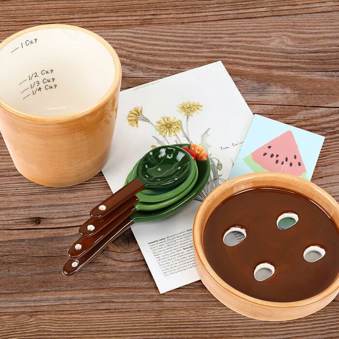 Measuring cups and spoons with cute designs on a wooden table, perfect for sweet discoveries in the kitchen.