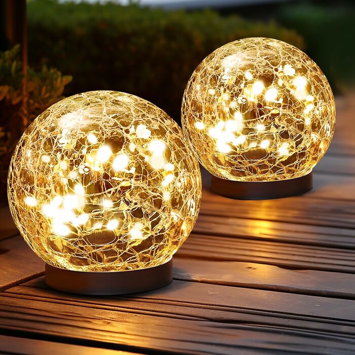 Glowing decorative orb string lights placed on wooden deck, showcasing unique weirdly wonderful Amazon items.