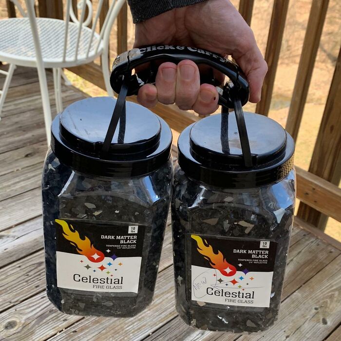 Hand holding two containers of fire glass, an essential item for first apartment adulting starter pack.