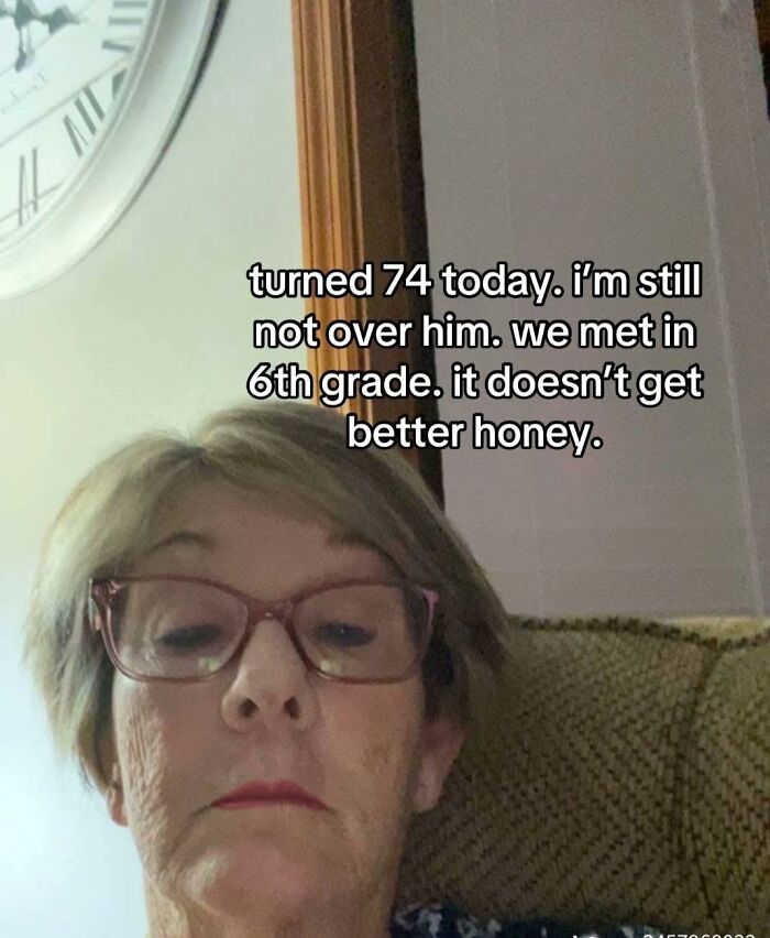 Older woman with glasses taking a selfie with a humorous meme about turning 74 and funny memes for a hard day.