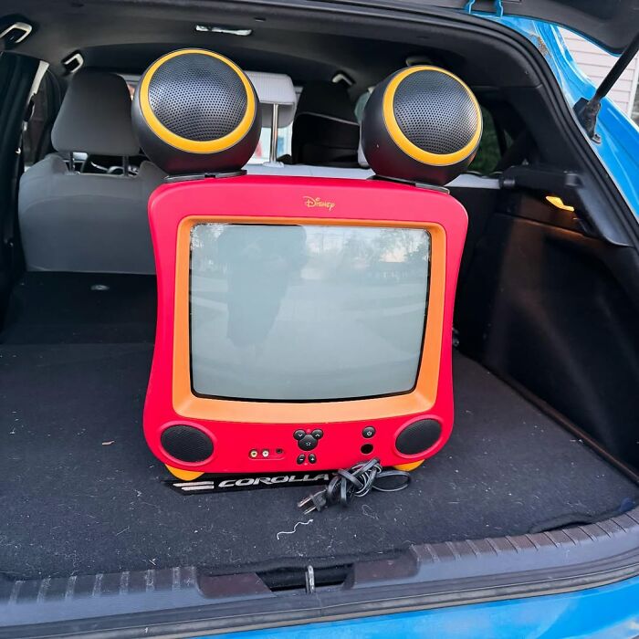 Retro Disney-themed secondhand TV with large round speakers sitting in the back of a car trunk in a cool secondhand finds collection.