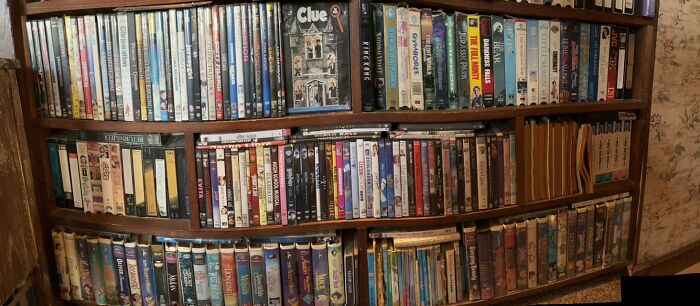 Wooden shelves filled with DVDs, VHS tapes, and board games, representing nostalgia for Millennials and Gen Z.