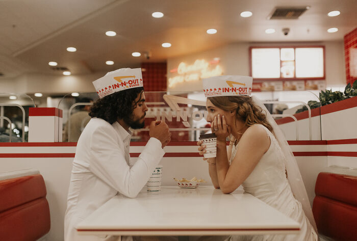 Bride and groom sharing a candid moment at a fast-food restaurant, creating unforgettable wedding photos with unique charm.