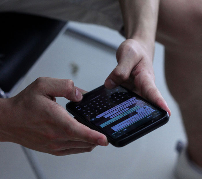 Person holding smartphone and texting, illustrating toxic dating trends people weirdly accept as normal.