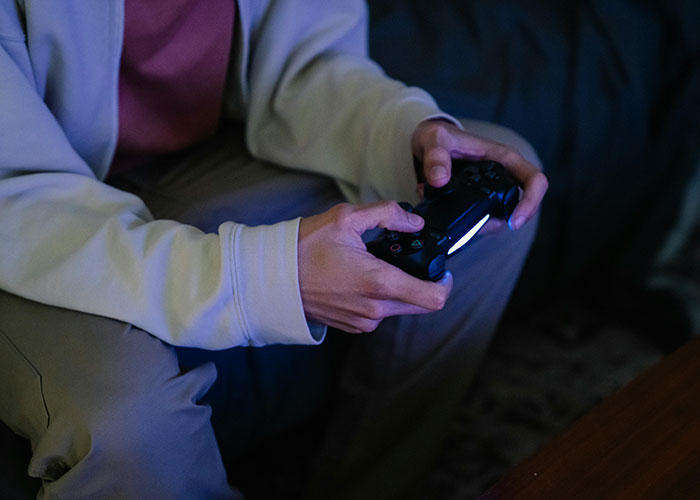 Person holding a gaming controller, highlighting themes of engagement and trust issues shared by 48 people.