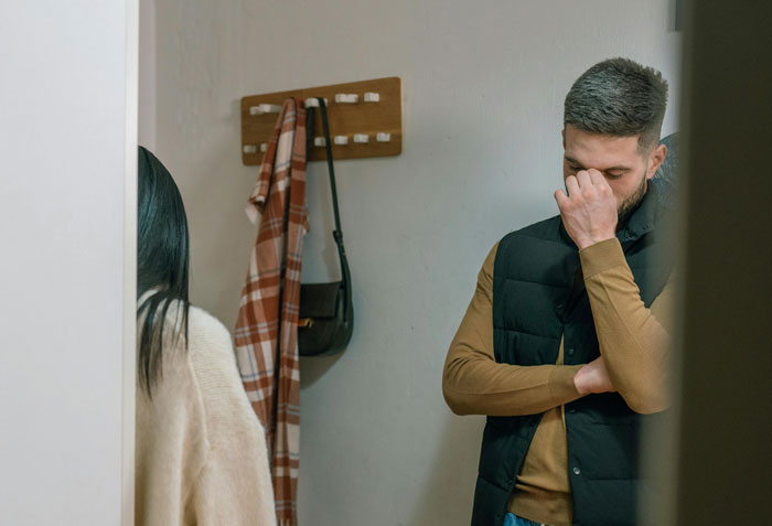 Man standing in a hallway looking distressed, showing regret after leaving his wife following a hospital stay.