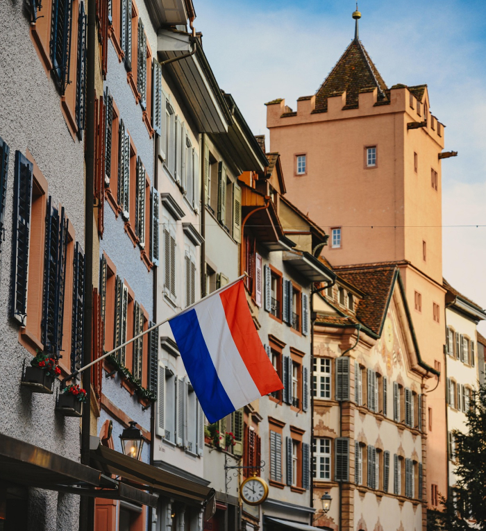 Street view in a top-ranked European country with traditional buildings and a vibrant flag representing best countries to live.